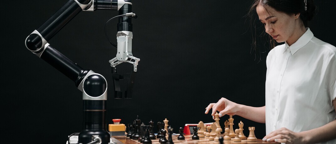 Frau spielt Schach mit einem Roboter